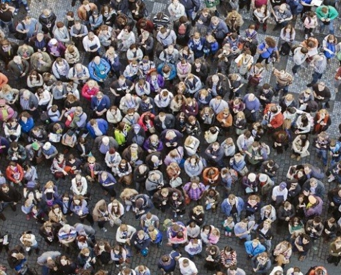 Een grote massa mensen is van boven gefotografeerd.