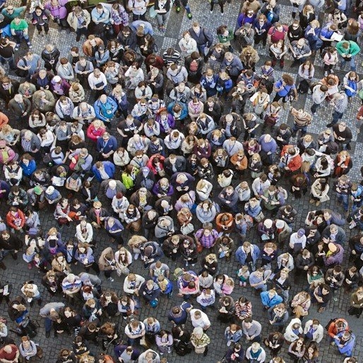 Een grote massa mensen is van boven gefotografeerd.